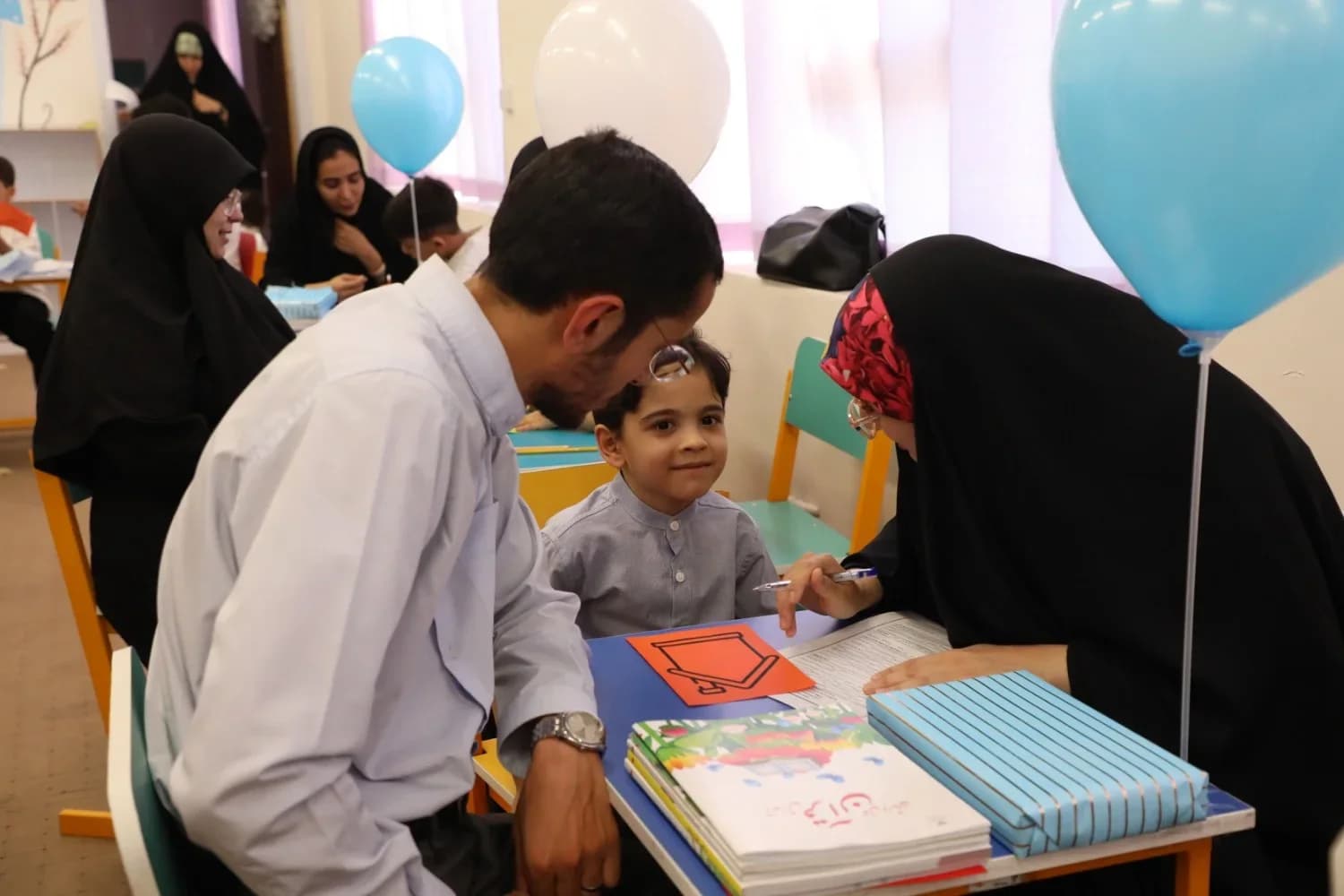 پدر و مادر کنار دخترشان در حال نقاشی