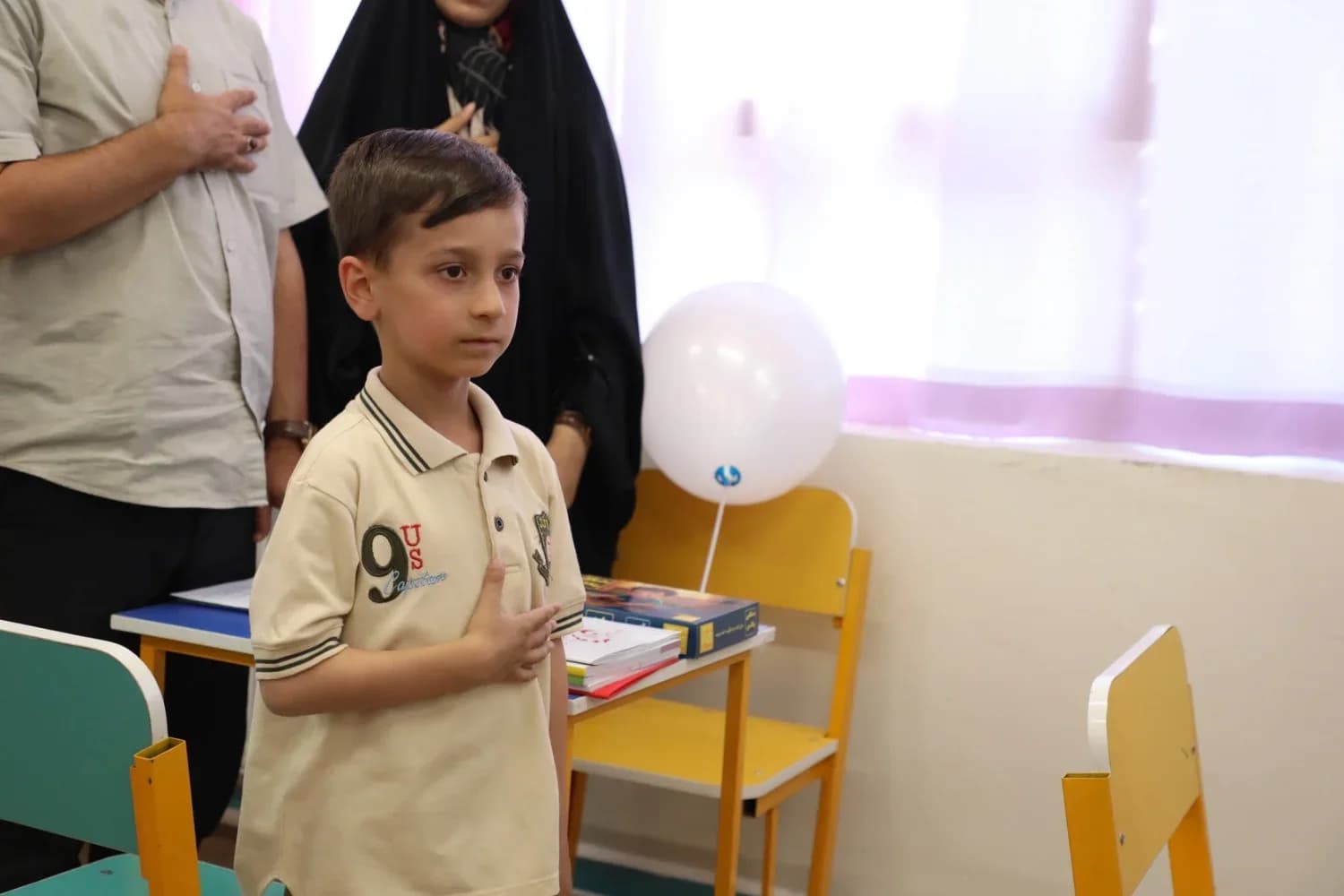 دانش‌آموز کلاس اولی کنار میزش